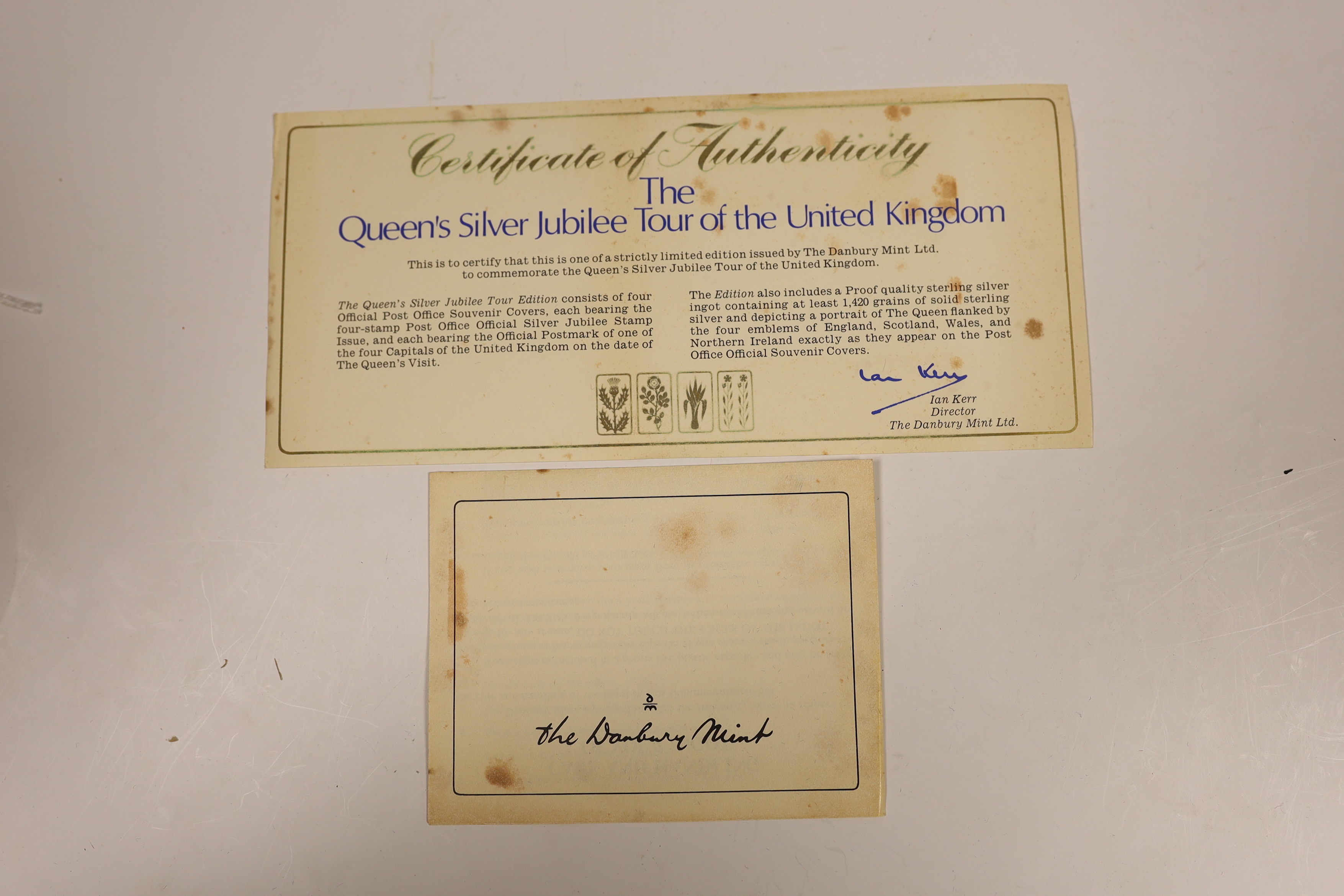 A cased Danbury Mint Queen Elizabeth II Silver Jubilee silver ingot and a Pobjoy Mint 25th anniversary of the Queen's coronation twin silver gilt medallions and First Day covers album
